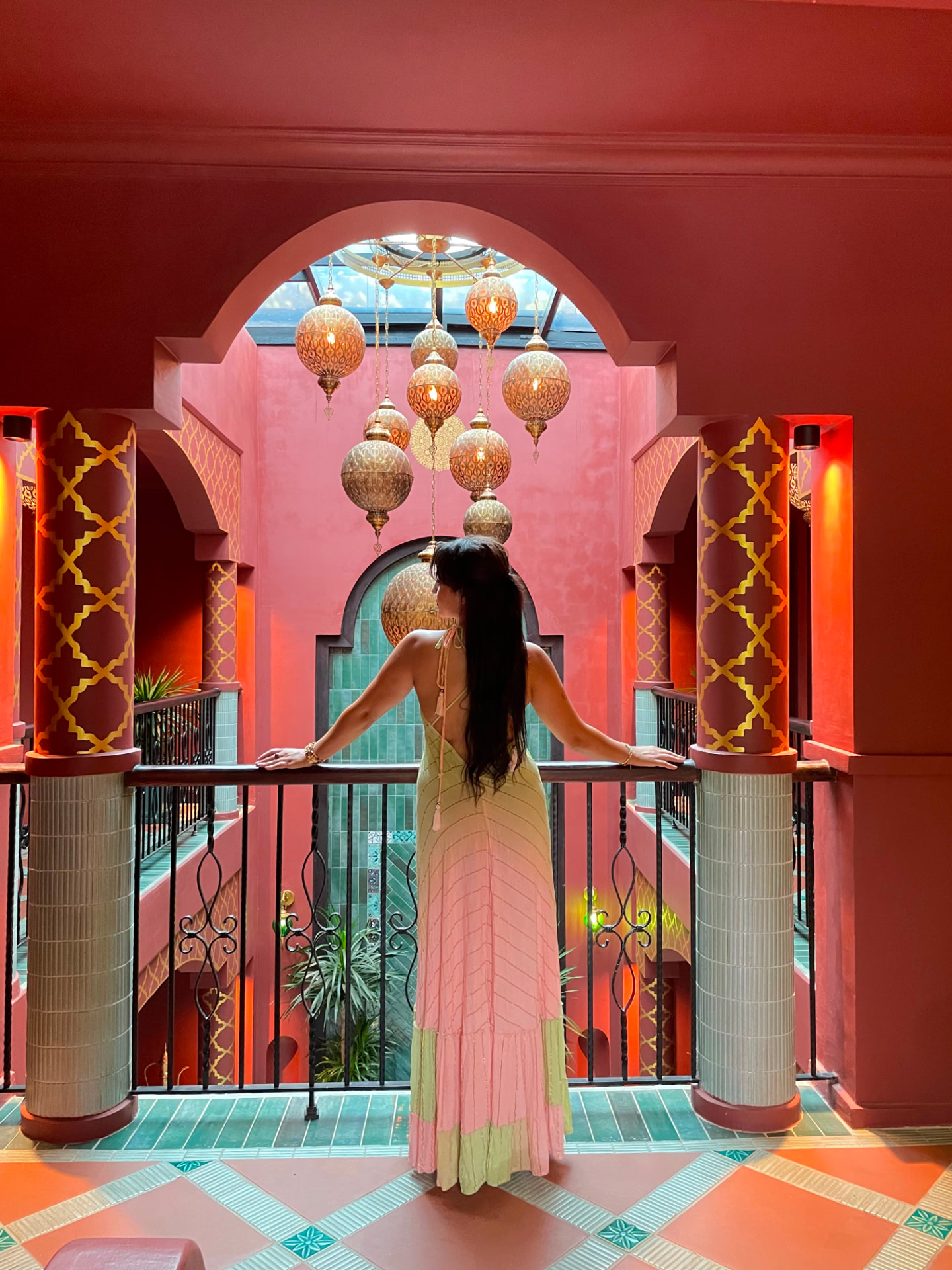 Guest on a riad balcony under hanging brass lanterns in Morocco