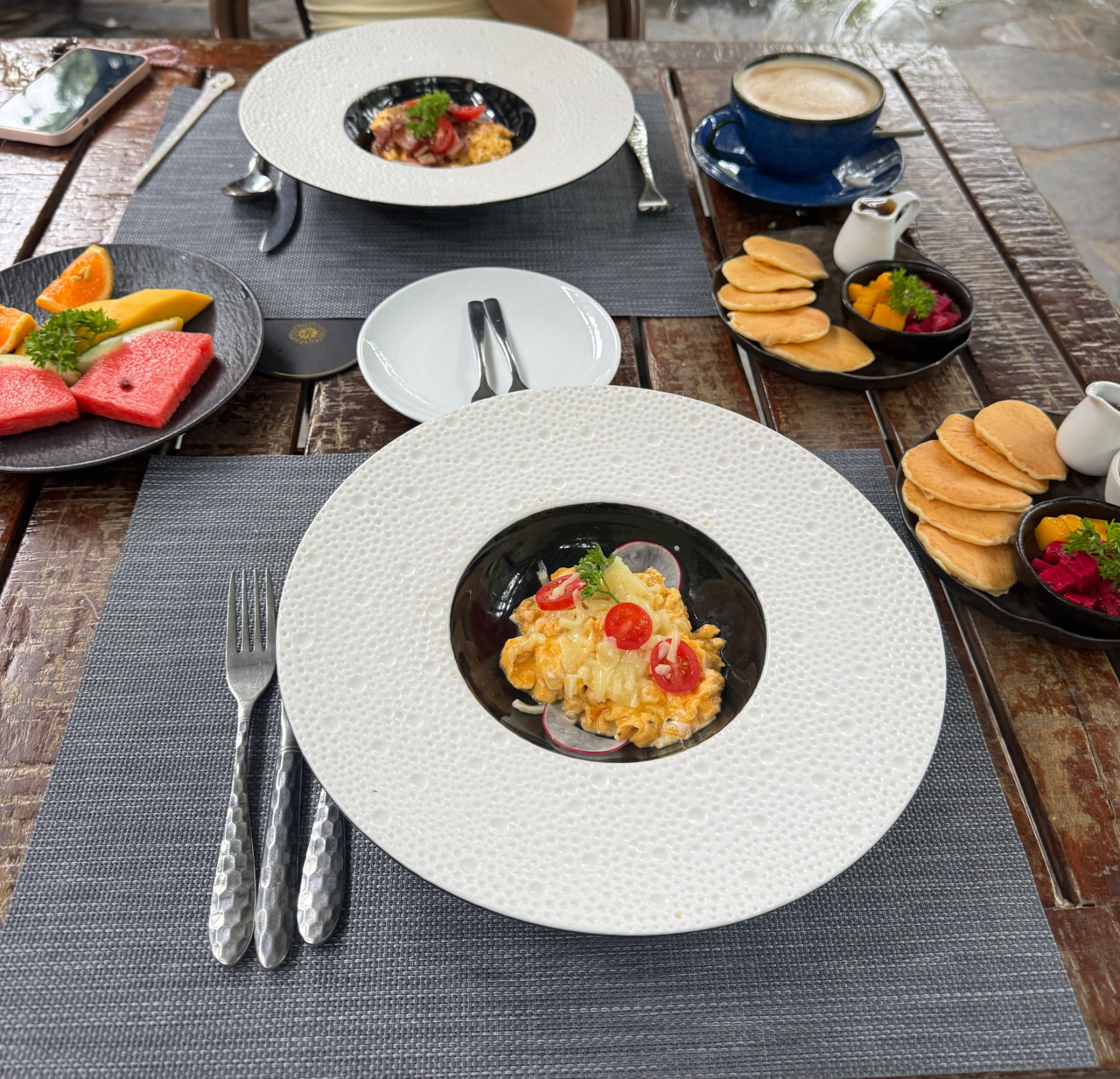 Breakfast laid out on a wooden table at a boutique stay in Vietnam